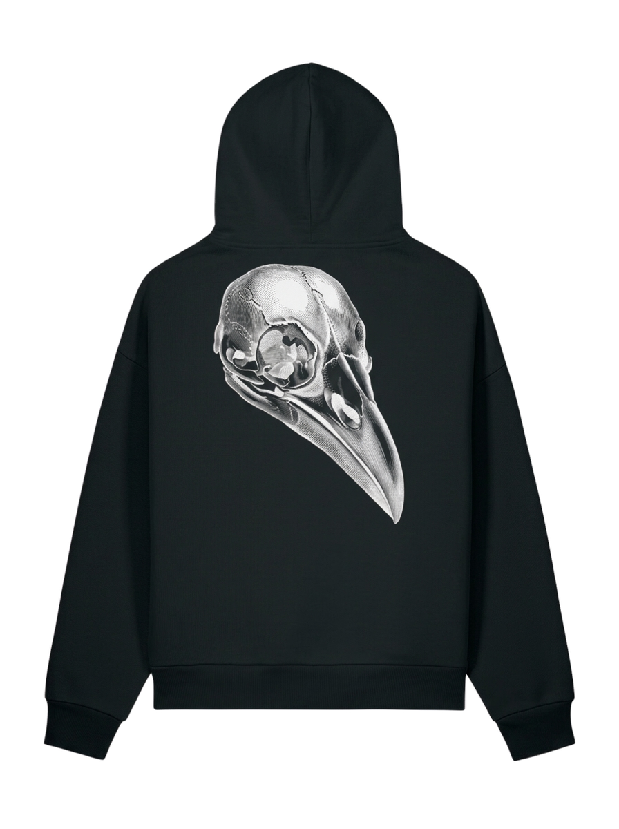A black pullover hoodie shown from the back, featuring a large, detailed silver-gray raven skull graphic printed across the center.