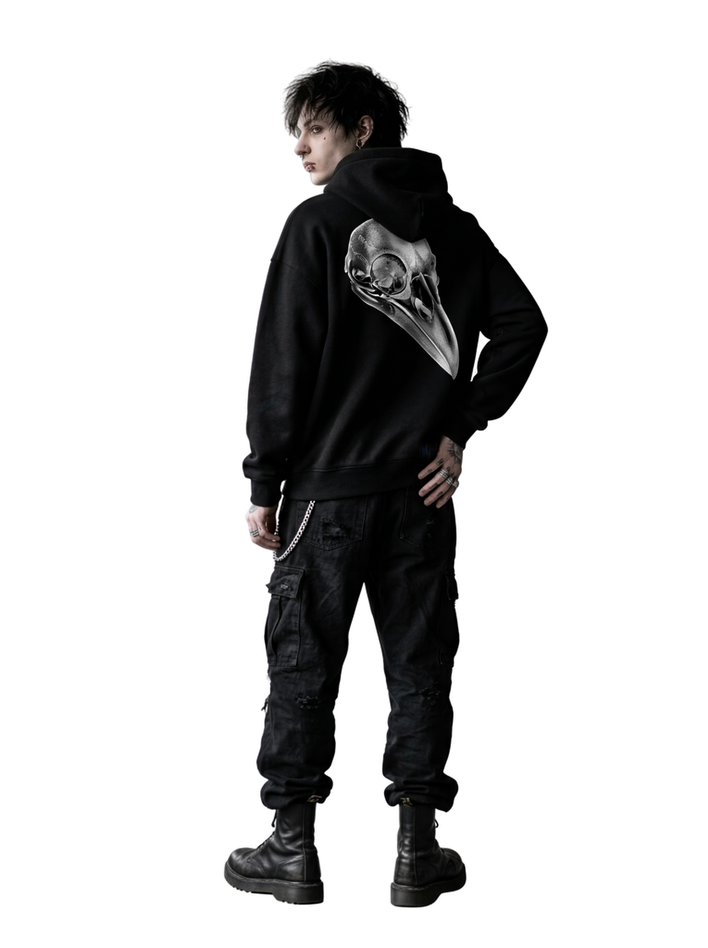 A person shown from the back wearing a black hoodie with a large white bird skull graphic on the back, paired with black cargo pants and black boots