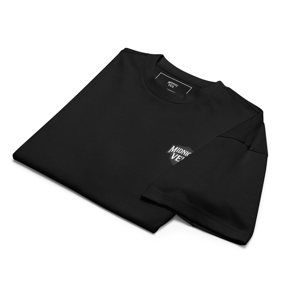 Folded black heavyweight box tee showing the Midnight Veil chest mark
