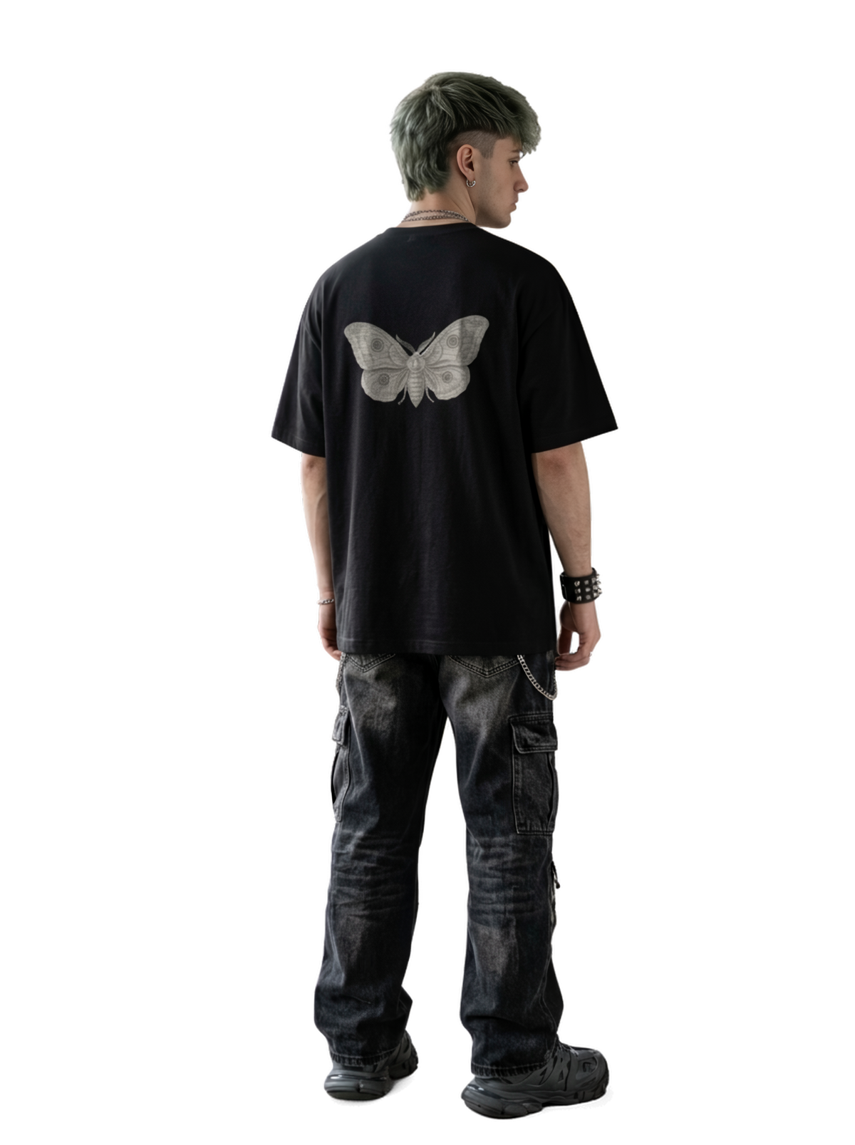 A person shown from the back wearing an oversized black T-shirt with a large light gray butterfly graphic on the back, paired with dark washed cargo pants and black shoes.