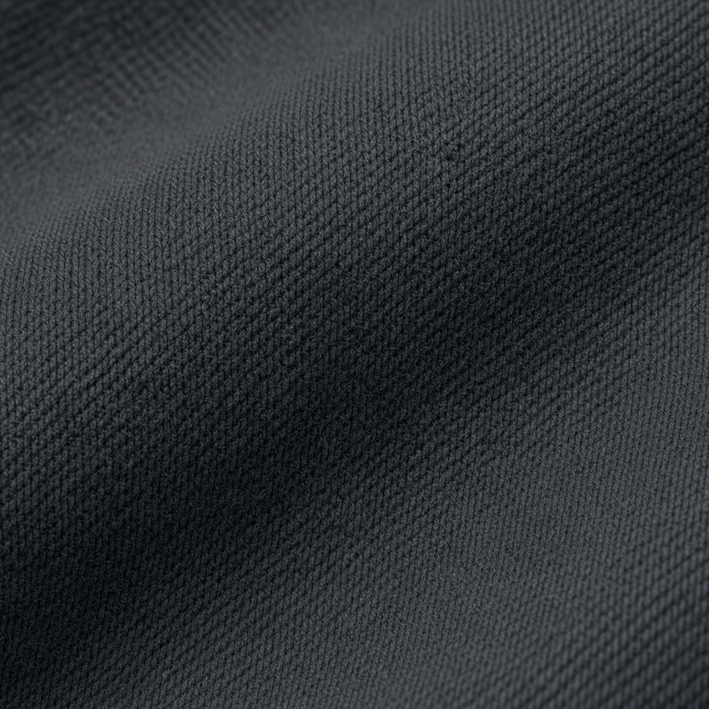Macro close-up photography of the premium 15oz 500GSM organic cotton loopback cross-weave fleece fabric texture on the Midnight Veil Obsidian Black Outer Shroud hoodie.
